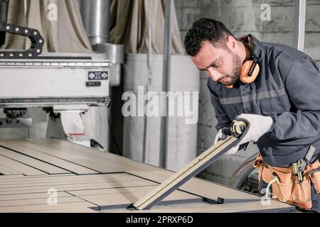 Wood turners measure and calculate the right size of workpiece dimension using hand and power tools. Cut, shape, rotate, smooth, and balance wood fixt Stock Photo