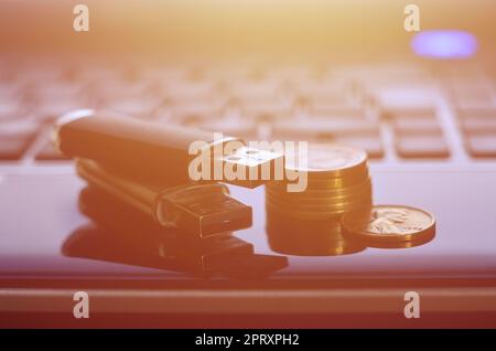 USB flash cards lying on black laptop case in front of his keyboard. The concept of earning on the Internet, online monetization and payment of virtua Stock Photo