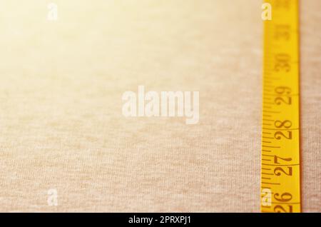 Premium Photo  Yellow measuring tape lies on a gray knitted fabric