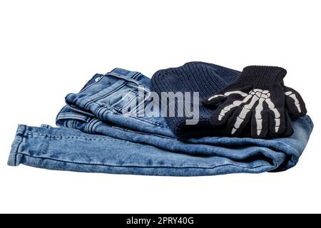 Halloween equipment. Close-up of a jeans, a blue knitted hat or cap and a pair of skeleton gloves isolated on a white background. Clipping path. Stock Photo