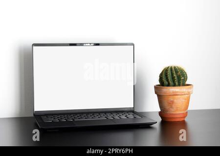 Laptop desktop screen mockup on white wall and black wooden table in office room Stock Photo