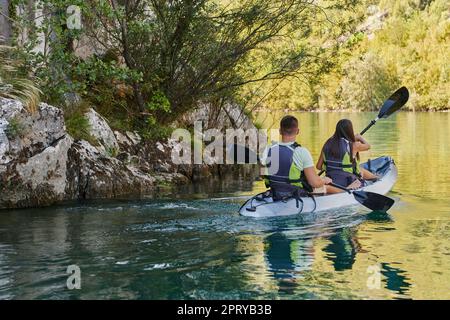 A young couple enjoying an idyllic kayak ride in the middle of a ...