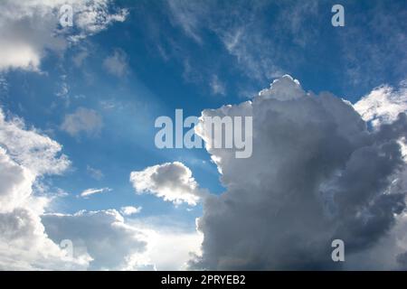 Bright and Dark clouds on the blue sky with sunrays Stock Photo