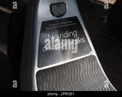 Warning label on escooter, no riding on sidewalks, wear a helmet follow ...