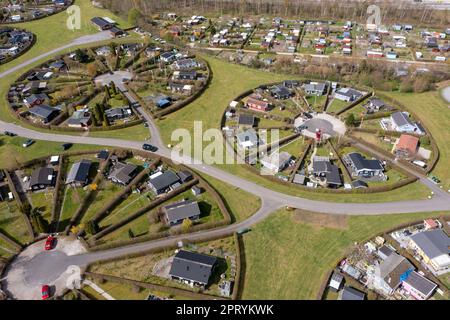 Brondby, Denmark. 27th Apr, 2023. From the air, the Danish garden city of Brondby Haveby near Copenhagen looks like the setting from a sci-fi movie. The 24 circular community gardens were laid out in the 1960s to a design by landscape architect Mygind. They resemble old Danish villages where residents met at the village well in the center to share news. (Shot with a drone). Credit: Stephan Schulz/dpa-Zentralbild/dpa/Alamy Live News Stock Photo