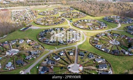 Brondby, Denmark. 27th Apr, 2023. From the air, the Danish garden city of Brondby Haveby near Copenhagen looks like the setting from a sci-fi movie. The 24 circular community gardens were laid out in the 1960s to a design by landscape architect Mygind. They resemble old Danish villages where residents met at the village well in the center to share news. (Shot with a drone). Credit: Stephan Schulz/dpa-Zentralbild/dpa/Alamy Live News Stock Photo