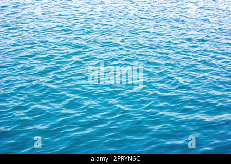 Light blue and turquoise sea water surface with waves texture in summer. Stock Photo
