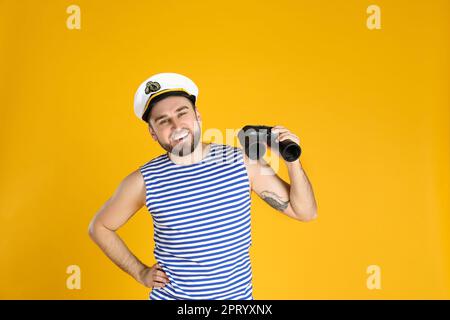 Happy sailor with binoculars on yellow background Stock Photo - Alamy