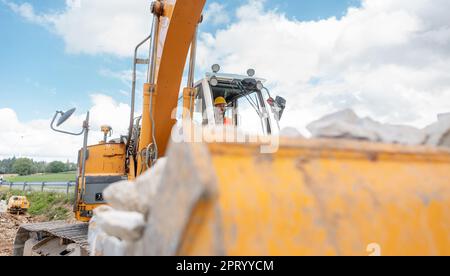 Construction worker operating the crawler excavator in underground works Stock Photo