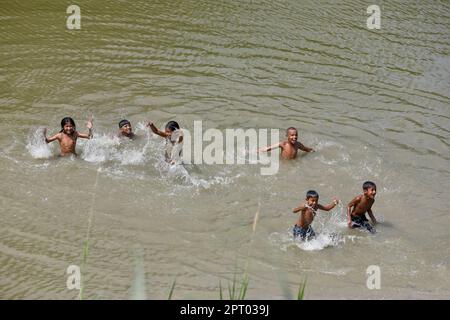 Shariatpur, Bangladesh - April 23, 2023: For the past few days, there has been intense heat wave in Bangladesh. In Shariatpur, the child is playing in Stock Photo