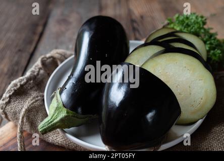 Raw and uncooked eggplant on wooden table background Stock Photo
