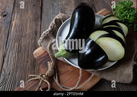Raw and uncooked eggplant on wooden table background Stock Photo
