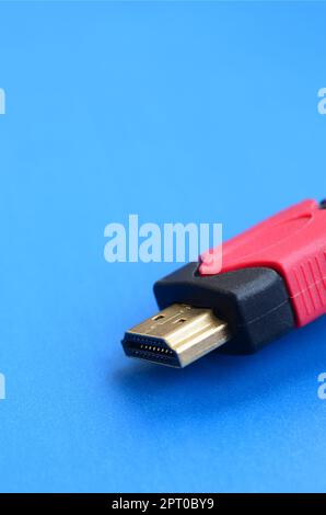 Black audio video HDMI computer cable on blue background. Close up of home entertainment connection cable for sound and video Stock Photo