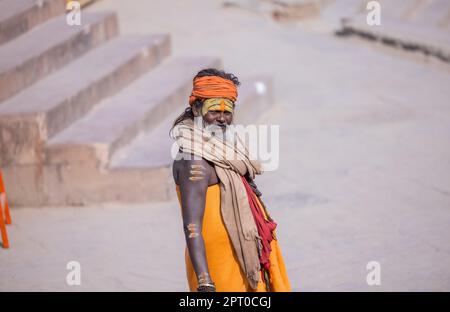 Portrait of Unidentified Indian sadhu baba walking on ghat near river ganges in varanasi city in traditional dress. Varanasi is oldest and holy city. Stock Photo