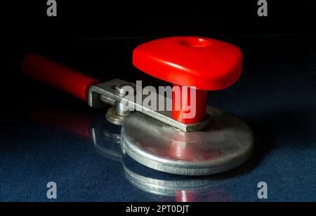 Manual mechanism with red handle on black background.rolling machine for glass jars Stock Photo