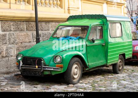 Belgrade, Serbia - February 23, 2023: Weathered and damaged green pickup old timer parked in the old cobble stone street Stock Photo