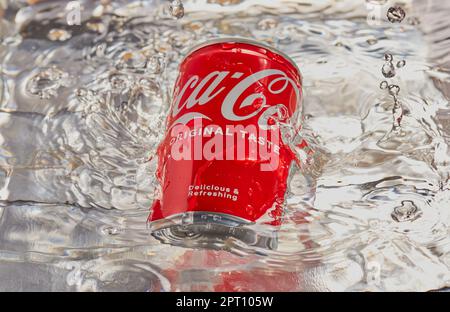 Can of coca cola with water being splashed over it. Stock Photo