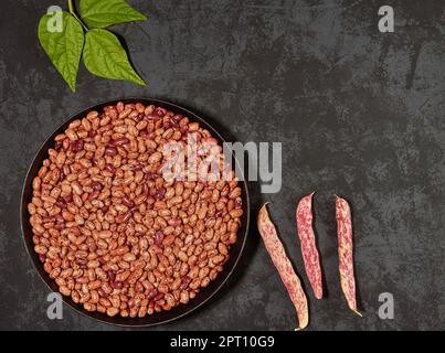 Grains of red beans in a frying pan on a dark background with a place to copy, top view Stock Photo