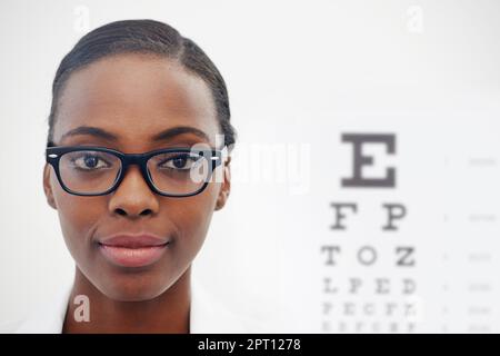 Shell get you seeing clearly. Portrait of a female optometrist standing beside a eye test chart Stock Photo