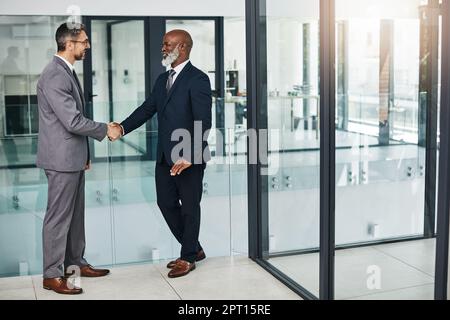 Never stop building meaningful relationships. two businessmen shaking hands in an modern office. Stock Photo