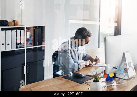 Execution is everything in business. a businessman working on his computer at his desk. Stock Photo