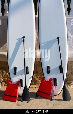 Standing up paddle boards and rowing along with life jackets Stock Photo
