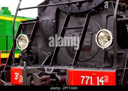 Two electric headlights on a retro train front on the rail platform close up. Stock Photo