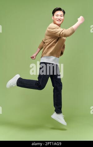 Full size photo of young happy excited crazy positive man jumping hold fists in victory Stock Photo