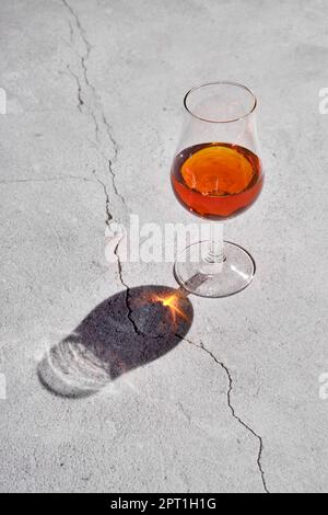 Glass of brandy on concrete background Stock Photo