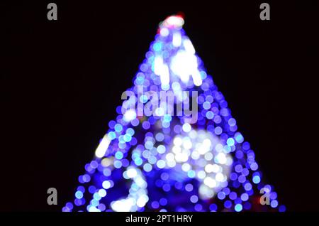 Blurred fragment of the New Year tree. Lots of round lights in blue Stock Photo