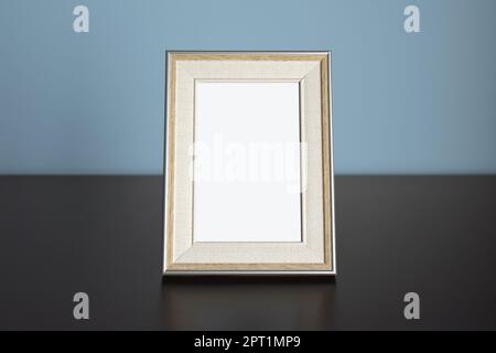 Photo frame picture Mockup on table with blue wall Stock Photo