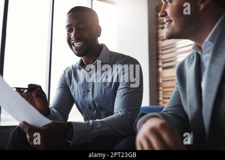 Weve got some top ideas down here. two businessmen going through paperwork in an office. Stock Photo