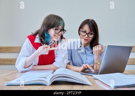 Young teenage female studying languages with teacher in classroom Stock Photo