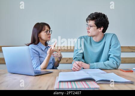 Young teenage male studying languages with teacher in classroom Stock Photo