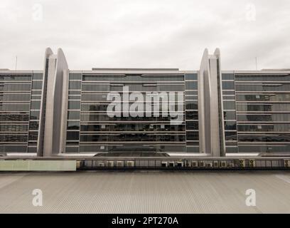 The air compressor units are arranged in a row on the roof in front of the modern office building, front view with the copy space. Stock Photo