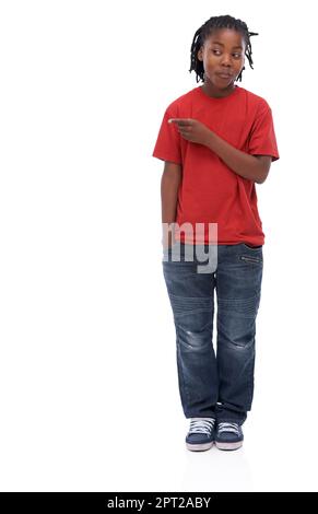 Can you believe this. A young African boy standing agisnt a white background pointing to the side Stock Photo