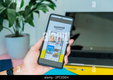 Benidorm, Spain - April 06, 2023: Woman hand holding phone with Lemon8 app. Lemon8 is video and photo-sharing social media platform catering users Stock Photo