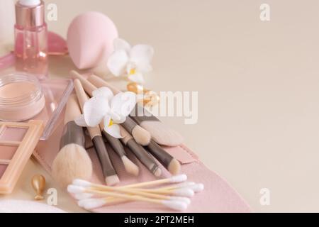 Skin care products and make up brushes on light beige close up, copy space. Natural beauty products and decorative cosmetics. Everyday woman face care Stock Photo