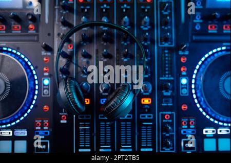 Top view on audio studio sound mixer panel with headphones on top. Recording board, faders, adjusting knobs and headphones Stock Photo