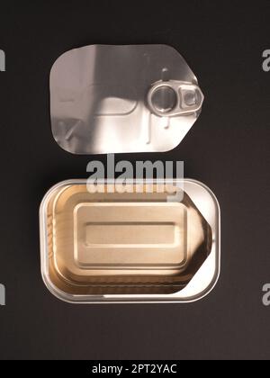 Opened aluminum fish can on a dark background Stock Photo