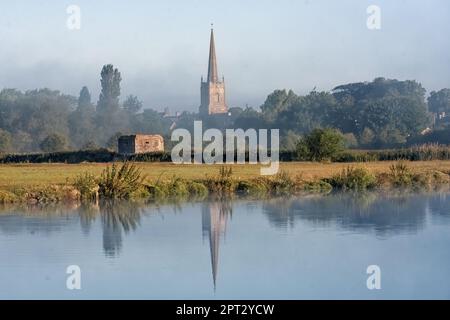 LECHLADE, GLOUCESTERSHIRE, UK - JULY 04, 2008:  View over the River Thames toward St Lawrence Church in soft morning light with reflection Stock Photo
