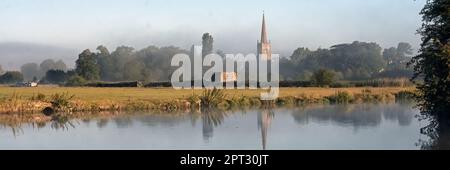 LECHLADE, GLOUCESTERSHIRE, UK - JULY 04, 2008:  Panorama view over the River Thames toward St Lawrence Church in soft morning light with reflection Stock Photo