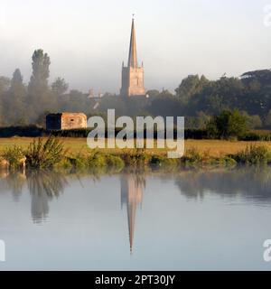LECHLADE, GLOUCESTERSHIRE, UK - JULY 04, 2008:  View over the River Thames toward St Lawrence Church in soft morning light with reflection Stock Photo