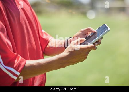 Strategy, tactics and coach with phone to educate, teach and inform soccer players to win a competitive football game. Modern sports coaching, digital Stock Photo