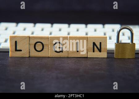 Word "login" written in wooden letters next to a padlock representing the concept of network security. Cyber ​​security, protection against fraud. Stock Photo