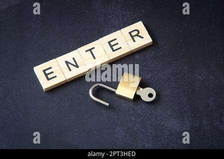 Word "enter" written in wooden letters next to a padlock representing the concept of network security. Cyber ​​security, protection against fraud. Stock Photo