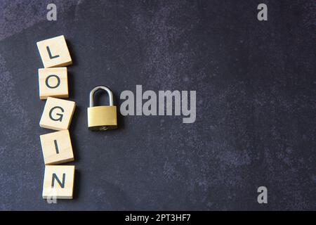 Word "login" written in wooden letters next to a padlock representing the concept of network security. Cyber ​​security, protection against fraud. Stock Photo