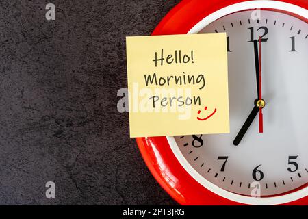 Clock and adhesive note with text and smiling icon - Hello Morning person Stock Photo
