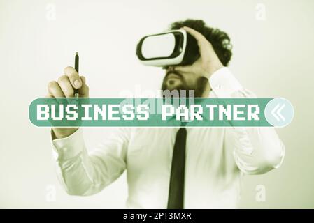 Hand writing sign Business Partner, Word for implemented to accomplish a target organizational goal Standig Man Holding Pen To Point Important Message Stock Photo