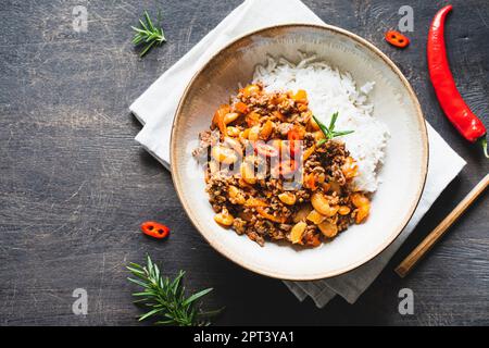 Chili Con Carne in bowl on dark background. Mexican cuisine. chili con carne - minced meat and vegetables stew in tomato sauce. Top view Stock Photo